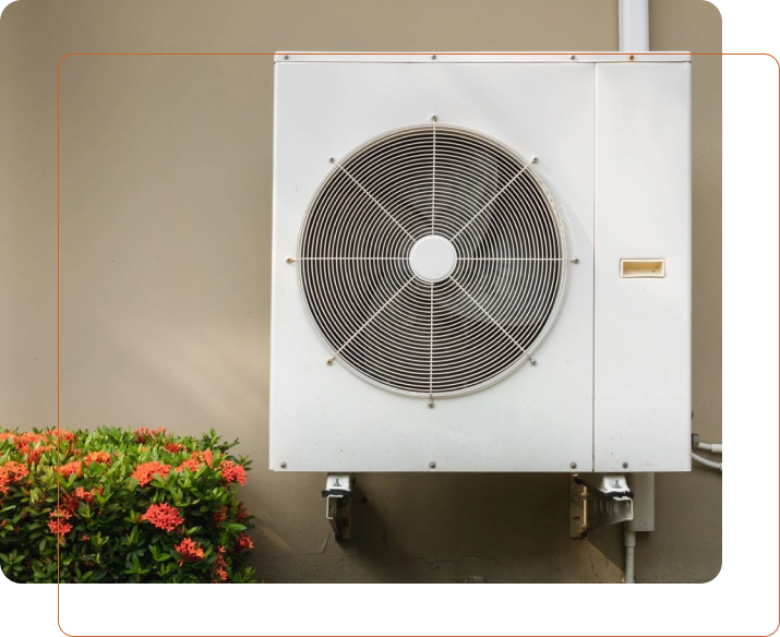 A white air conditioner mounted on the side of a building.