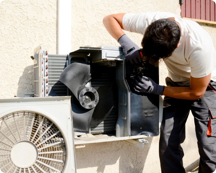 A man working on an air conditioner unit.