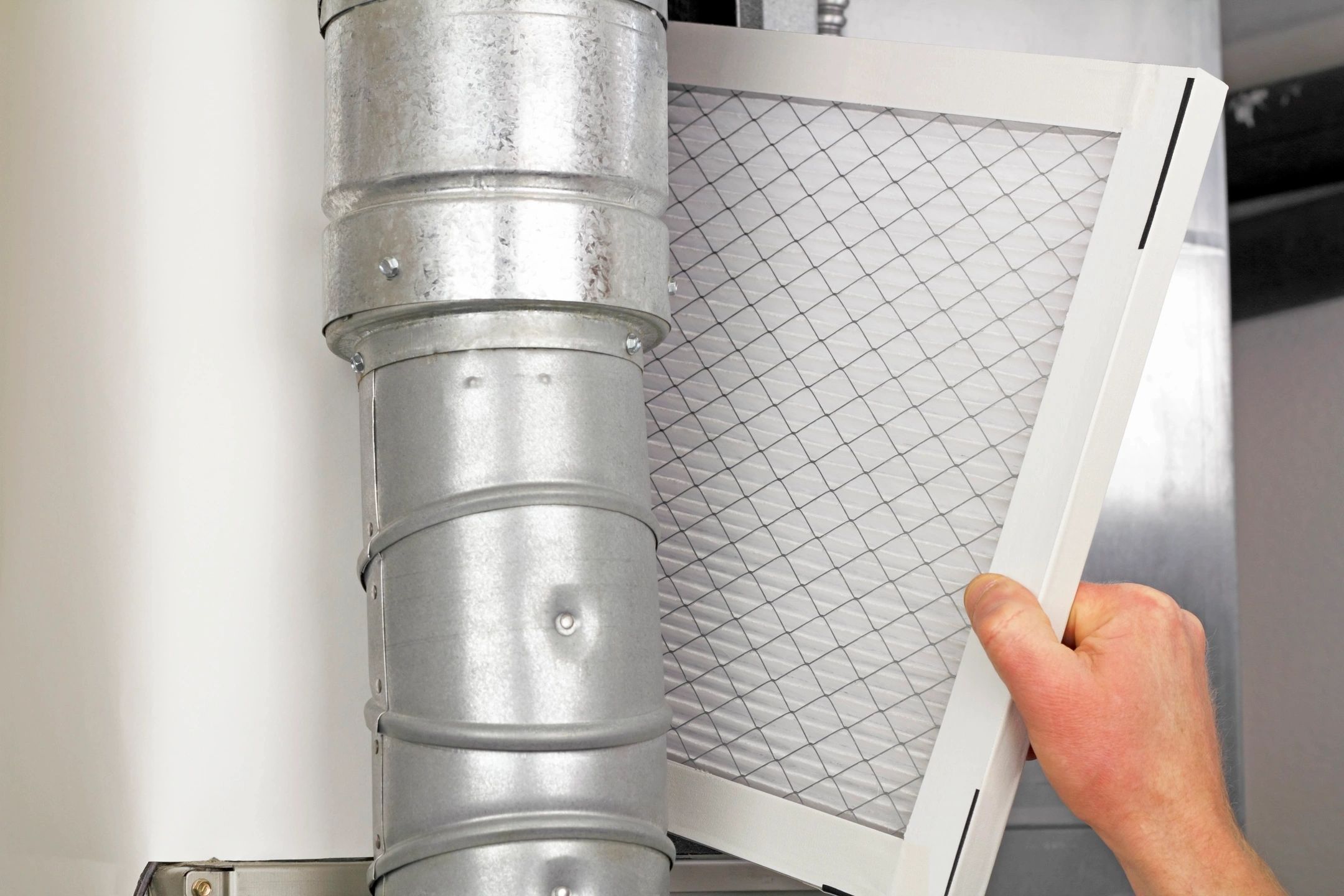 Person pulling a filter out of a furnace